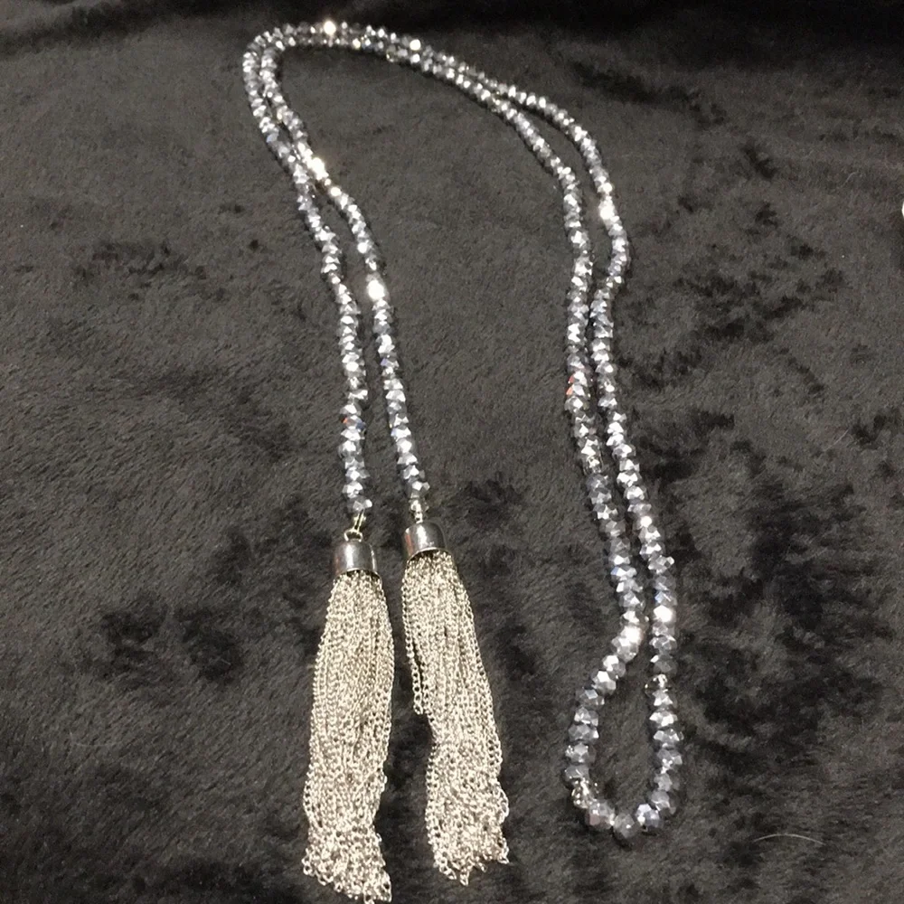 Woman’s grey and clear faceted bead necklace with silver tone tassels